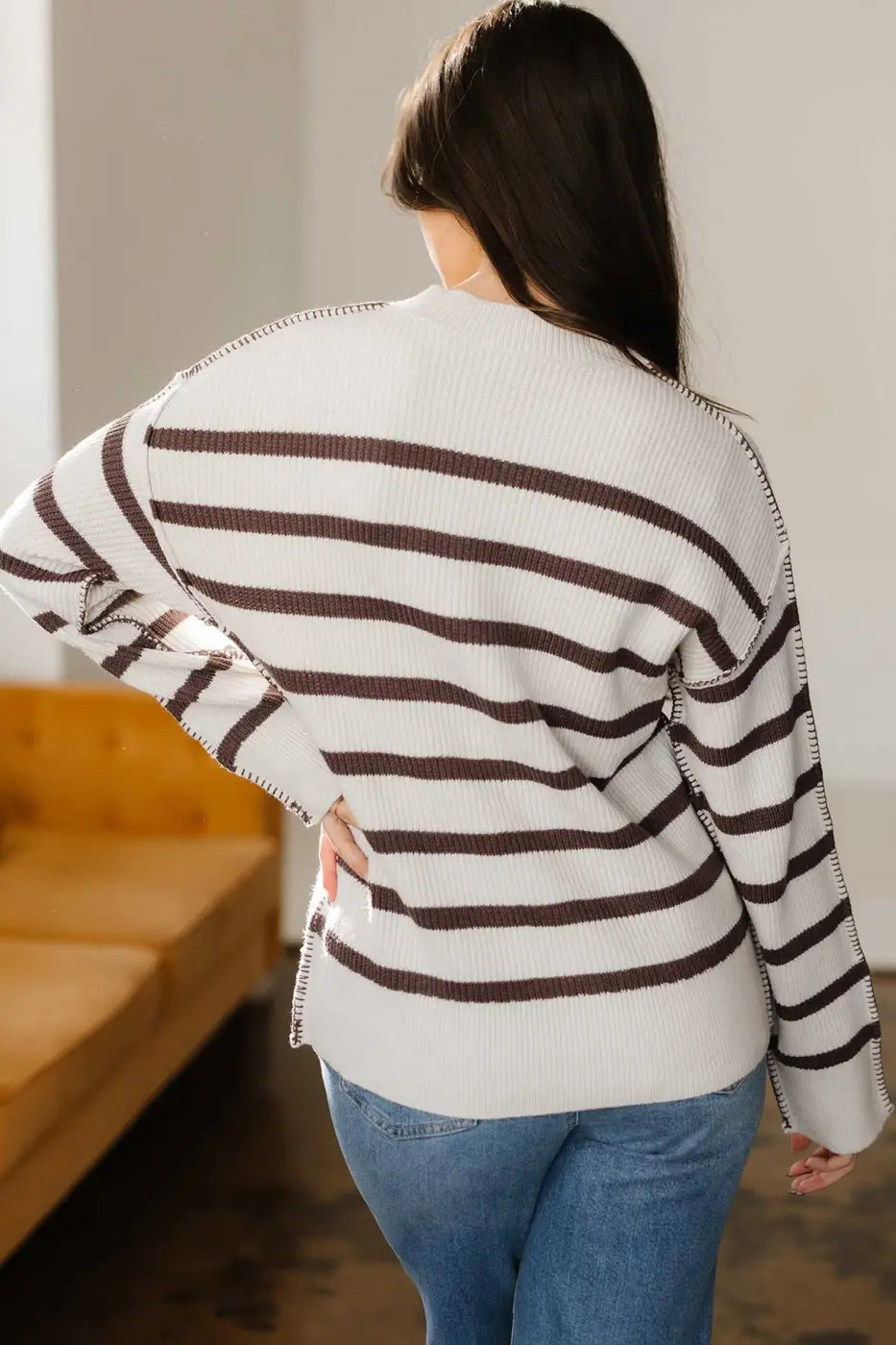 Back view of cream and brown striped Henley jumper, highlighting drop shoulders and cozy knit design.