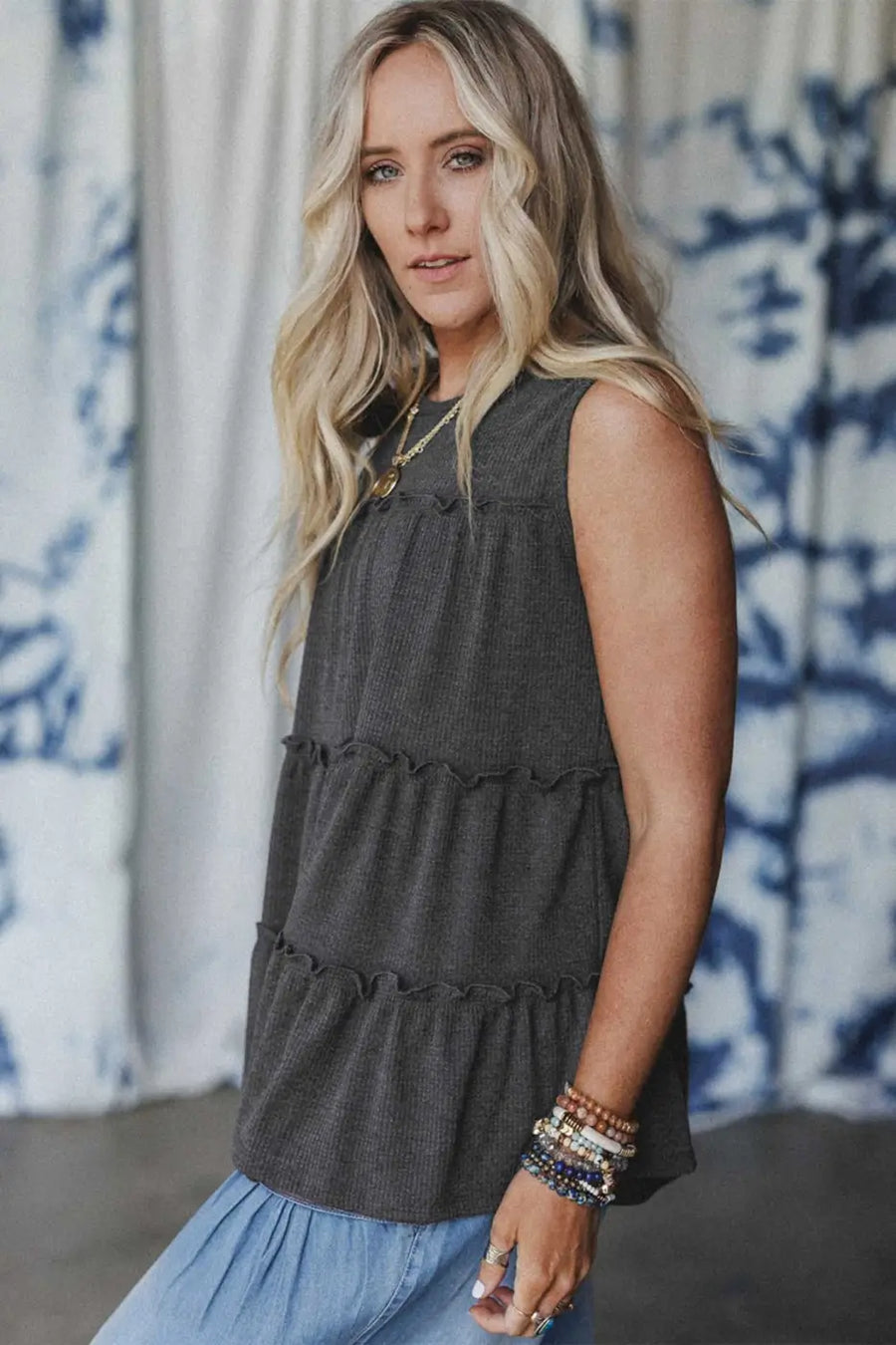Side profile of dark grey tiered frill tank top for women showing sleeveless cut and layered frill design.
