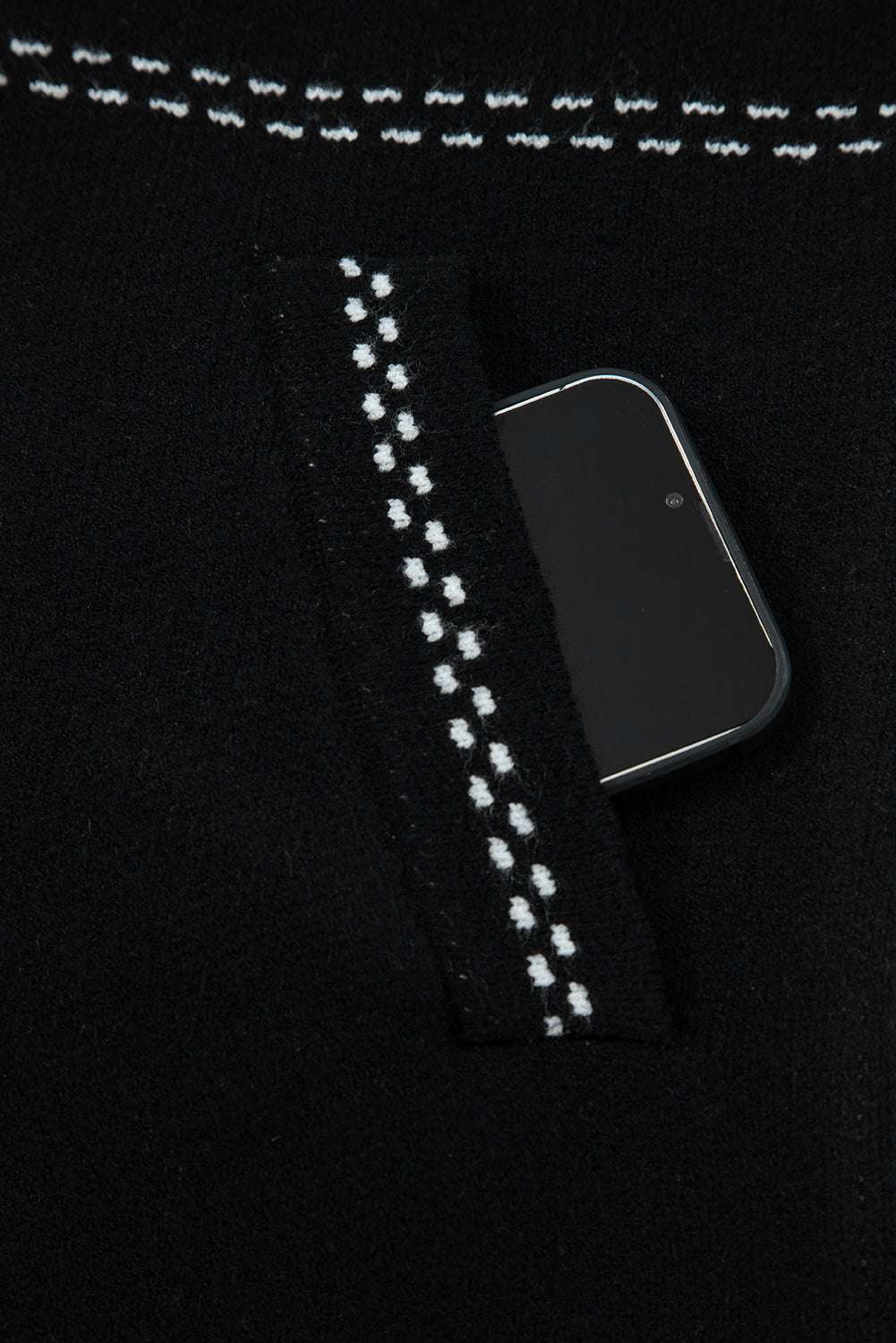 Pocket detail of Women's Black Contrast Trim Knitted Cardigan with phone inside, showcasing functionality and stitched trim.