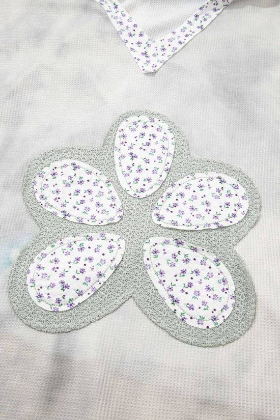 Floral fabric pieces arranged in a flower shape on a gray background