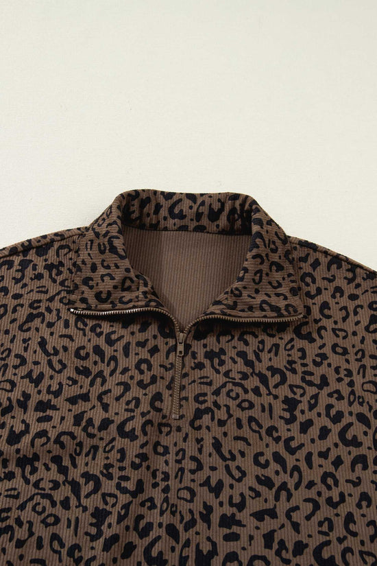 Close-up of brown leopard print corduroy half-zip jumper collar. Features ribbed inner lining and bold animal print pattern.