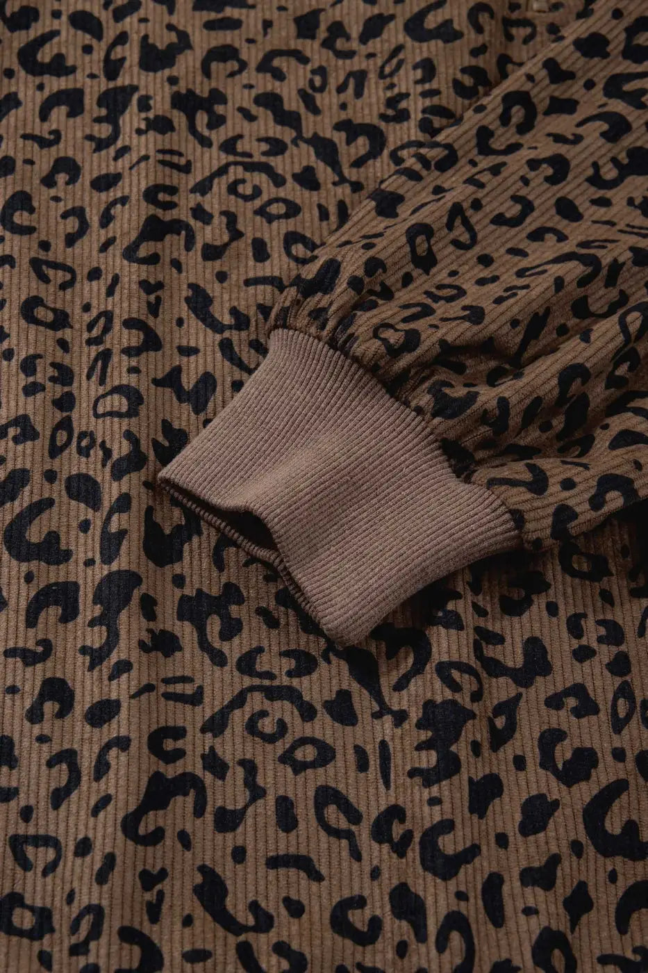 Cuff detail of Women's Brown Leopard Print Corduroy Half-Zip Jumper, featuring ribbed knit and all-over leopard pattern.