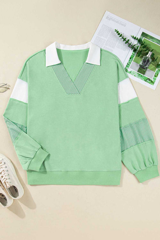 Flat lay of Curve Jade Stripe V‑Neck Sweatshirt for Women with striped patchwork sleeves and white collar, ideal for fall casual wear.