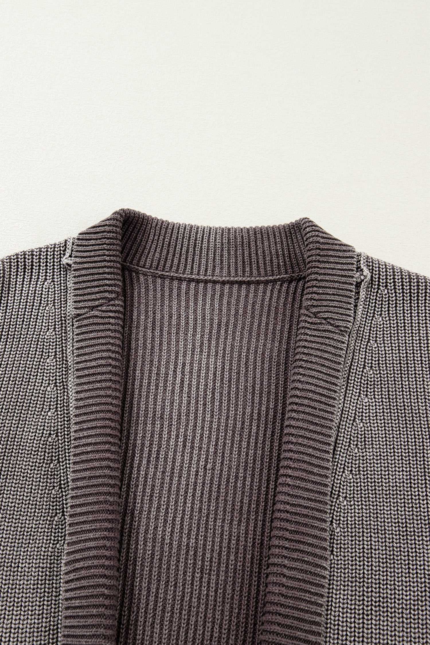 Close-up of neckline and ribbed detailing on brown stonewash patchwork knit open cardigan, highlighting its textured knit craftsmanship.