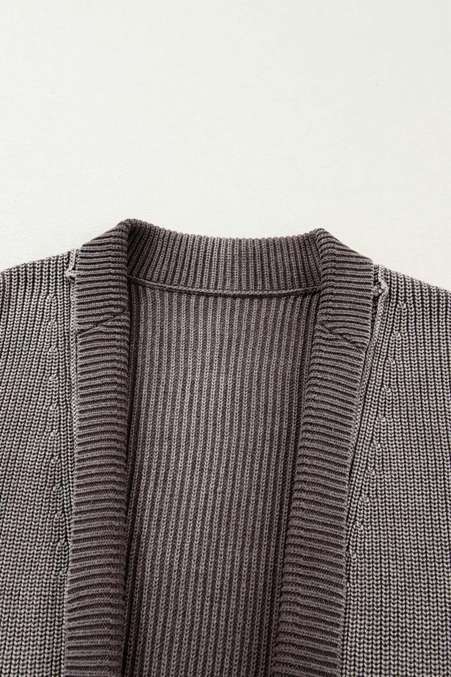 Close-up of neckline and ribbed texture on women's stonewash patchwork knit open cardigan, highlighting soft knit details.