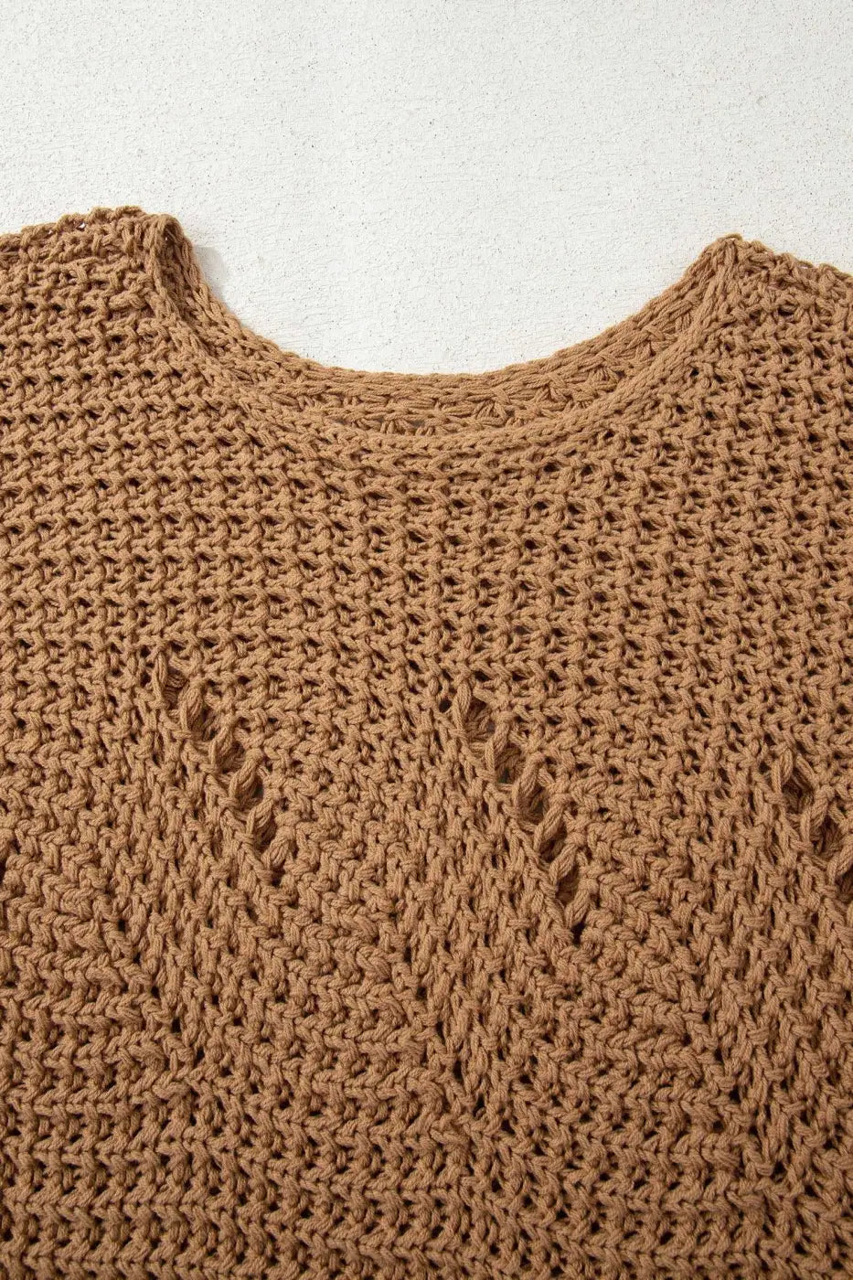Close-up of brown wide sleeve hollow knit jumper neckline and open-knit pattern, highlighting breathable and textured fabric.