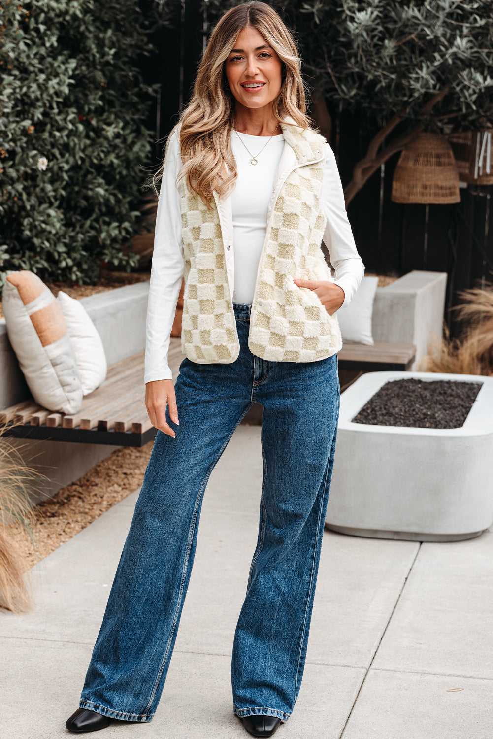 Woman wearing a Sherpa Fleece Vest, white shirt, and blue jeans outdoors.