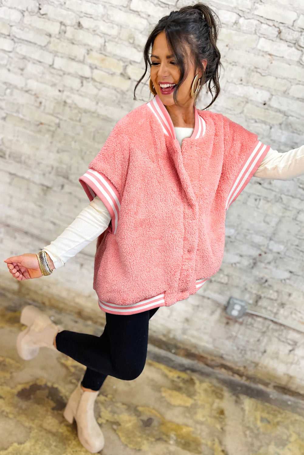 Winter outfit featuring pink sherpa vest layered over knitwear