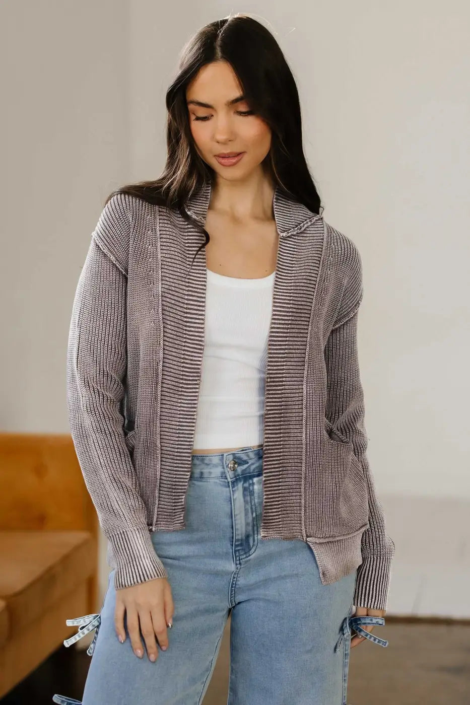 Women's stonewash patchwork knit open cardigan in brown with ribbed texture, styled casually over a white tank top and light denim jeans.