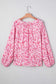 Front view of Pink Floral Lightweight Blouse on hanger, featuring v-neckline and long sleeves with floral print.