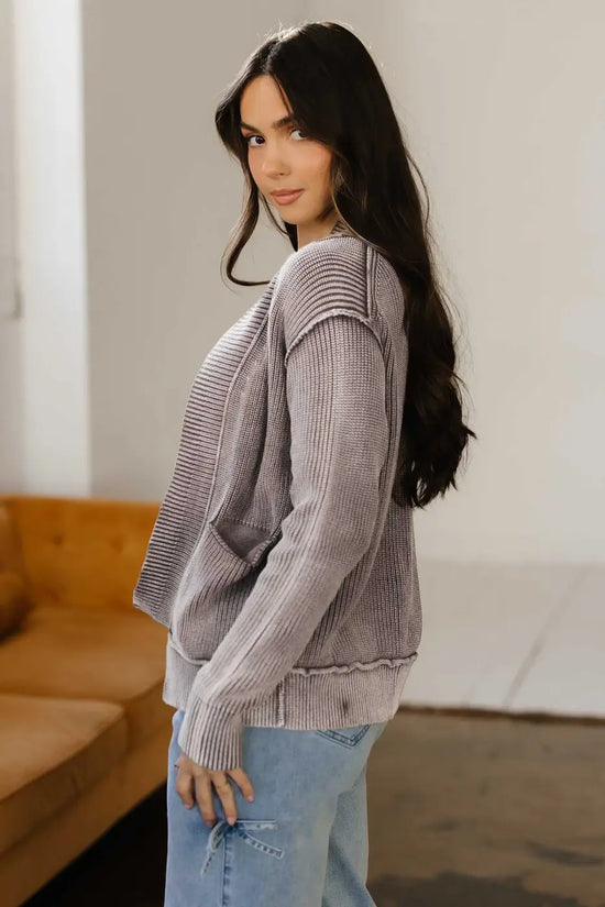 Side profile of model in brown Women's Stonewash Patchwork Knit Open Cardigan, styled with light denim for a casual look.
