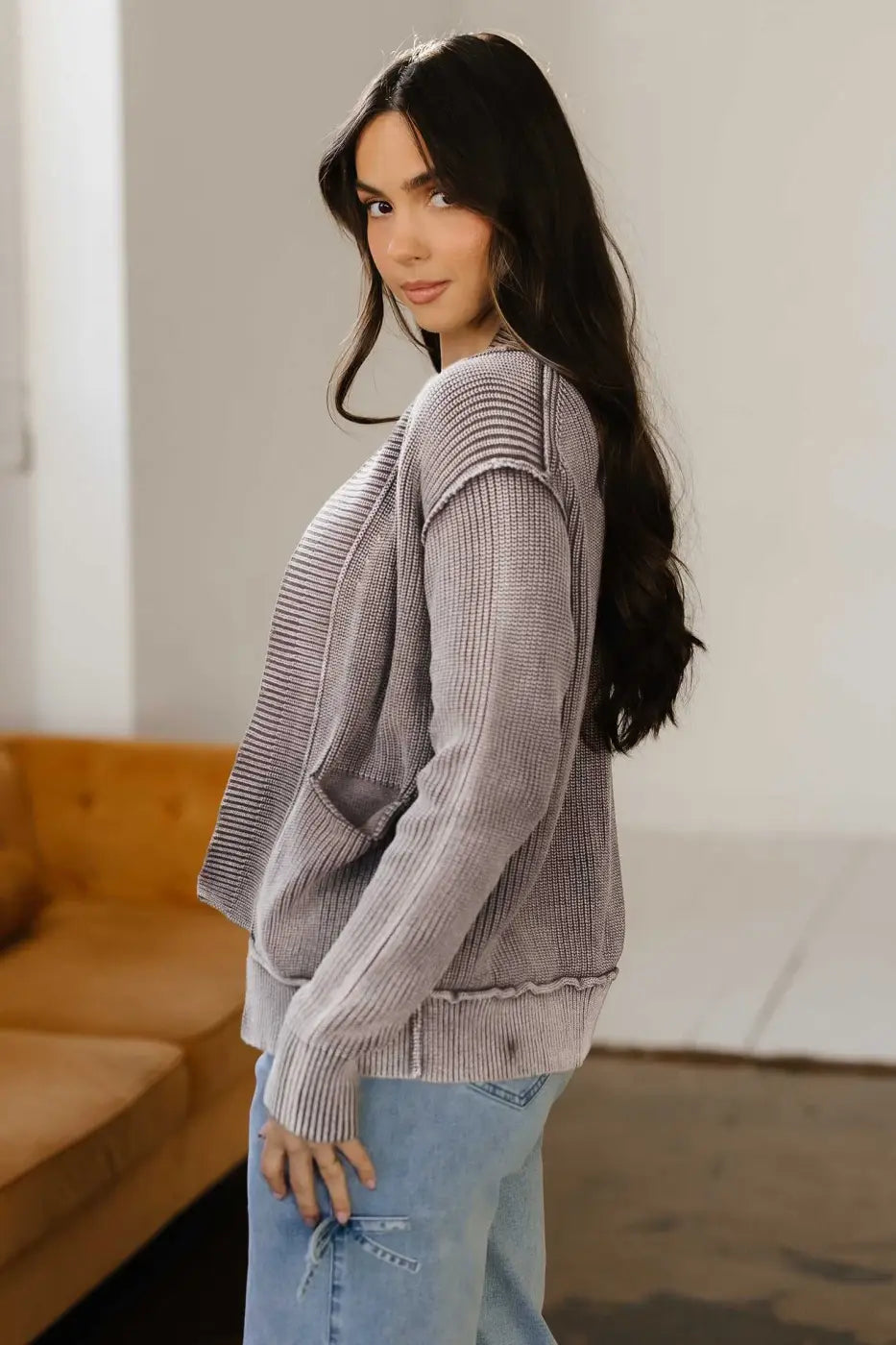Side profile of model in brown Women's Stonewash Patchwork Knit Open Cardigan, styled with light denim for a casual look.