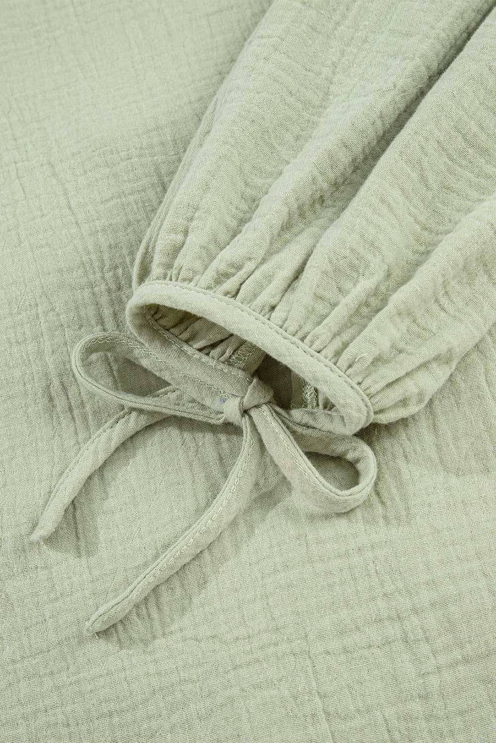 Detail of Meadow Cotton Blouse sleeve with elastic cuff and bow tie, highlighting lightweight cotton texture and Southern Belle style.