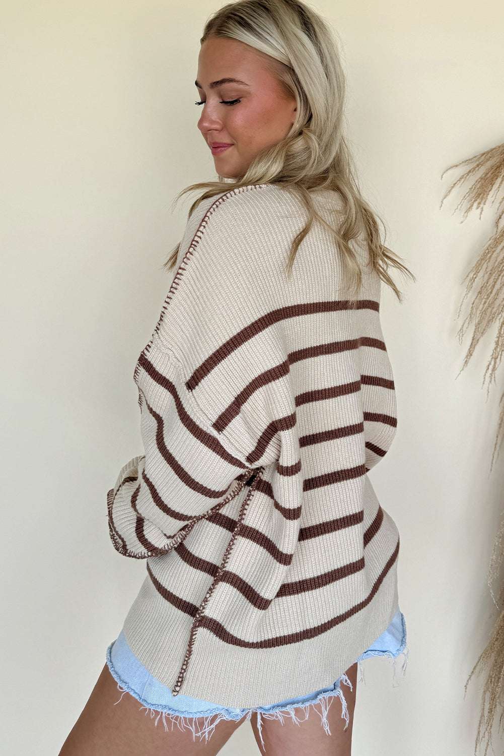 Back view of casual slouchy striped Henley jumper in beige and brown. Lightweight women’s knit sweater ideal for autumn daily wear.