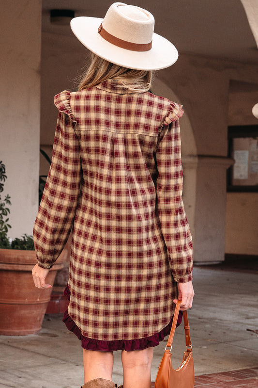 Person wearing a plaid dress and white hat with a brown band, standing outdoors.