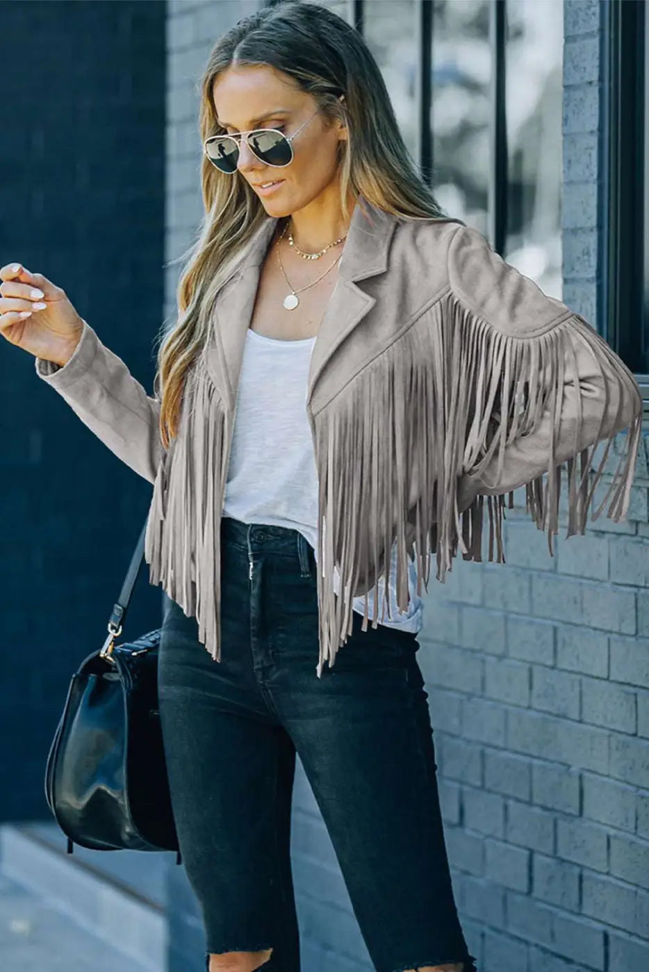 Gray cropped fringe faux suede jacket worn with sunglasses and black handbag, showcasing trendy casual outerwear for women.
