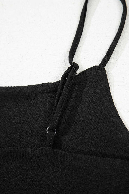 Detail of adjustable spaghetti strap on black crop top, showcasing quality stitching and stretch fabric for comfort.