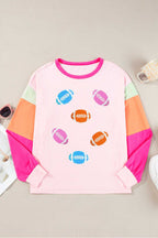 Flat lay of Pink GAME DAY Graphic Top with colorful football graphics and color block long sleeves, ideal for sporty casual outfits.