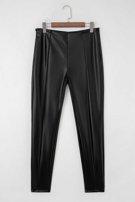 Flat lay of Black Vegan Leather Leggings – High‑Rise Skinny Fit showing front seam detailing and sleek faux leather texture.