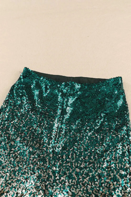 Waistband detail of green sequin flared trousers with gold gradient. Elastic waist and medium stretch for comfortable party wear.