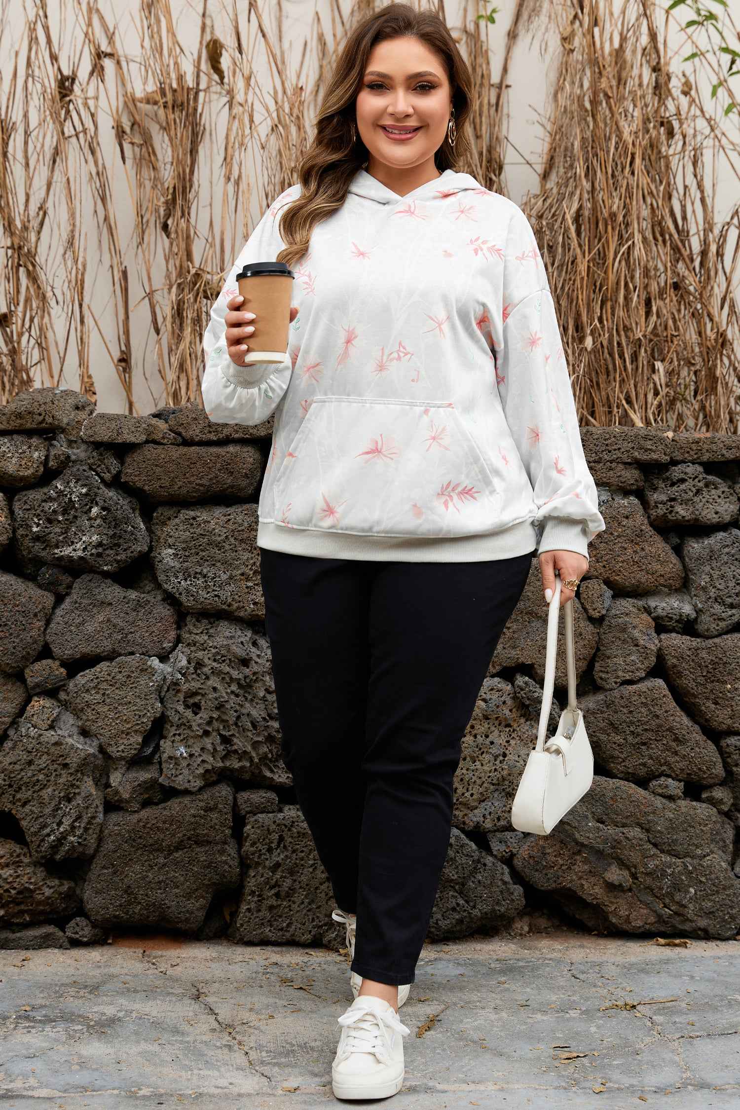 Model wearing Curve Floral Print Hoodie paired with black pants and white sneakers, showcasing a casual fall outfit for plus size women.