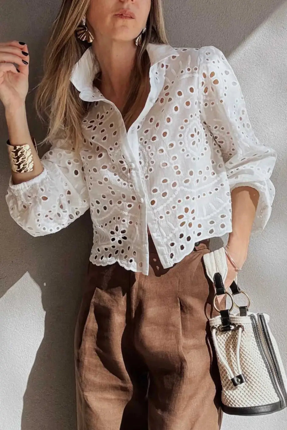 Chic styling of Cutwork Embroidered Crop Top in white cotton, worn with brown pants and statement accessories.