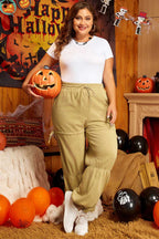 Model wearing Women's Terry Knit Drawstring Sweatpants in beige plus size, styled for a festive casual look with Halloween decor.