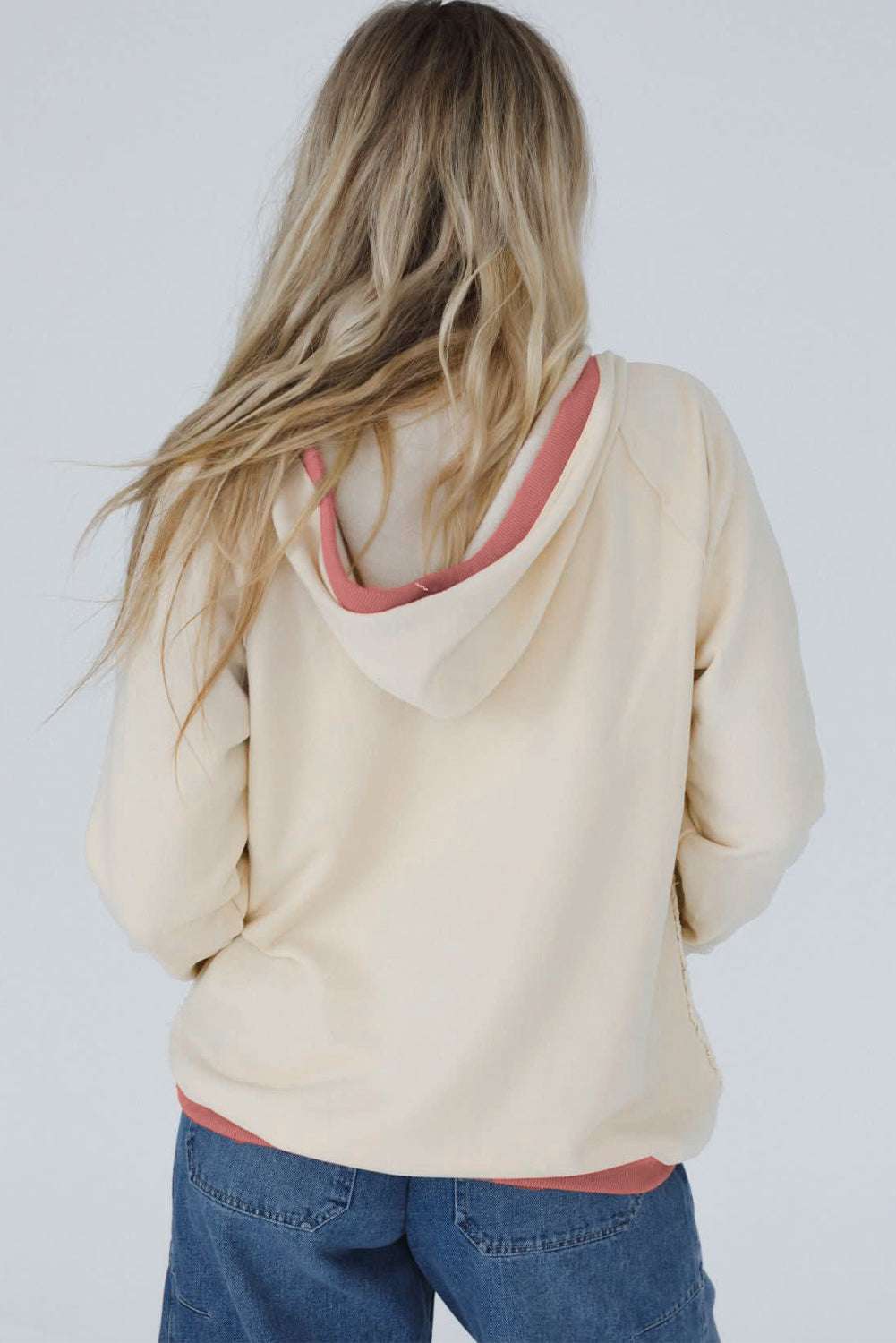 Rear angle of Women's White Contrast Trim Crochet Knit Hoodie highlighting relaxed fit and pink contrast trim on hood and hem.