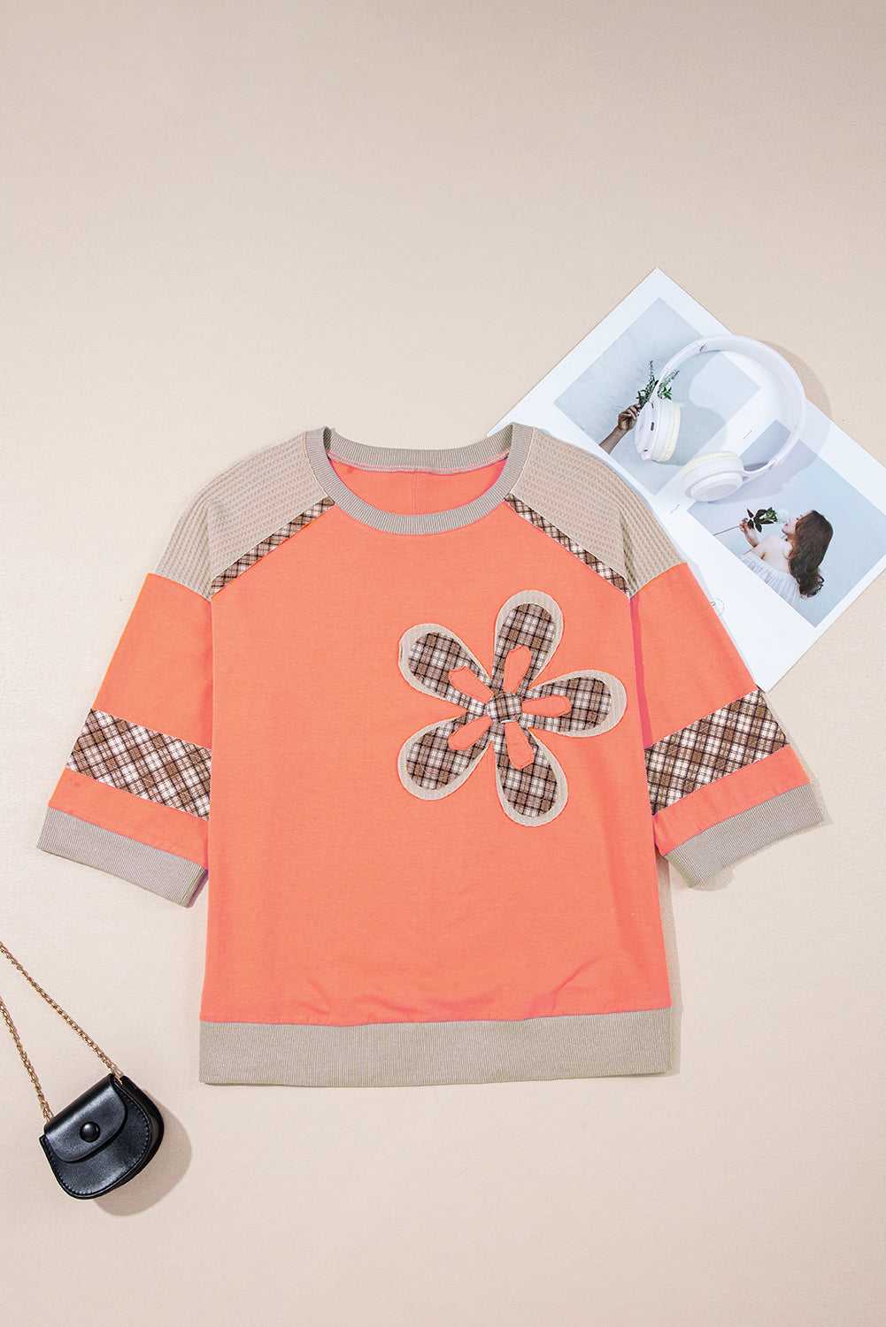 Autumn plaid floral long sleeve top in orange with patchwork flower design, waffle knit sleeves, and ribbed hem, laid flat for display.