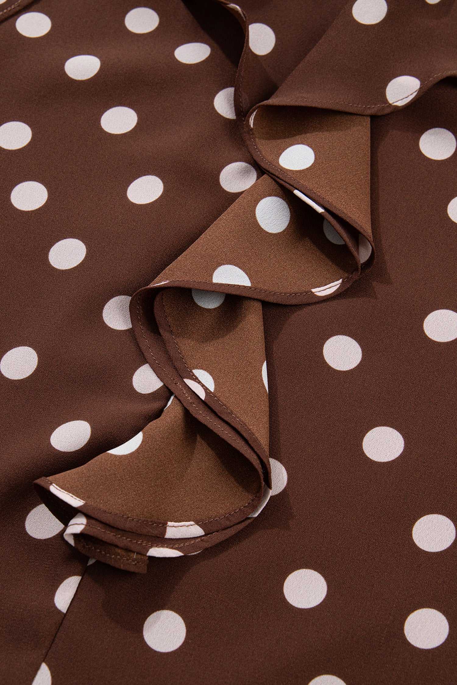 Zoomed-in view of the ruffled front design on the coffee polka dot chiffon blouse, highlighting the soft texture and elegant polka dot print.