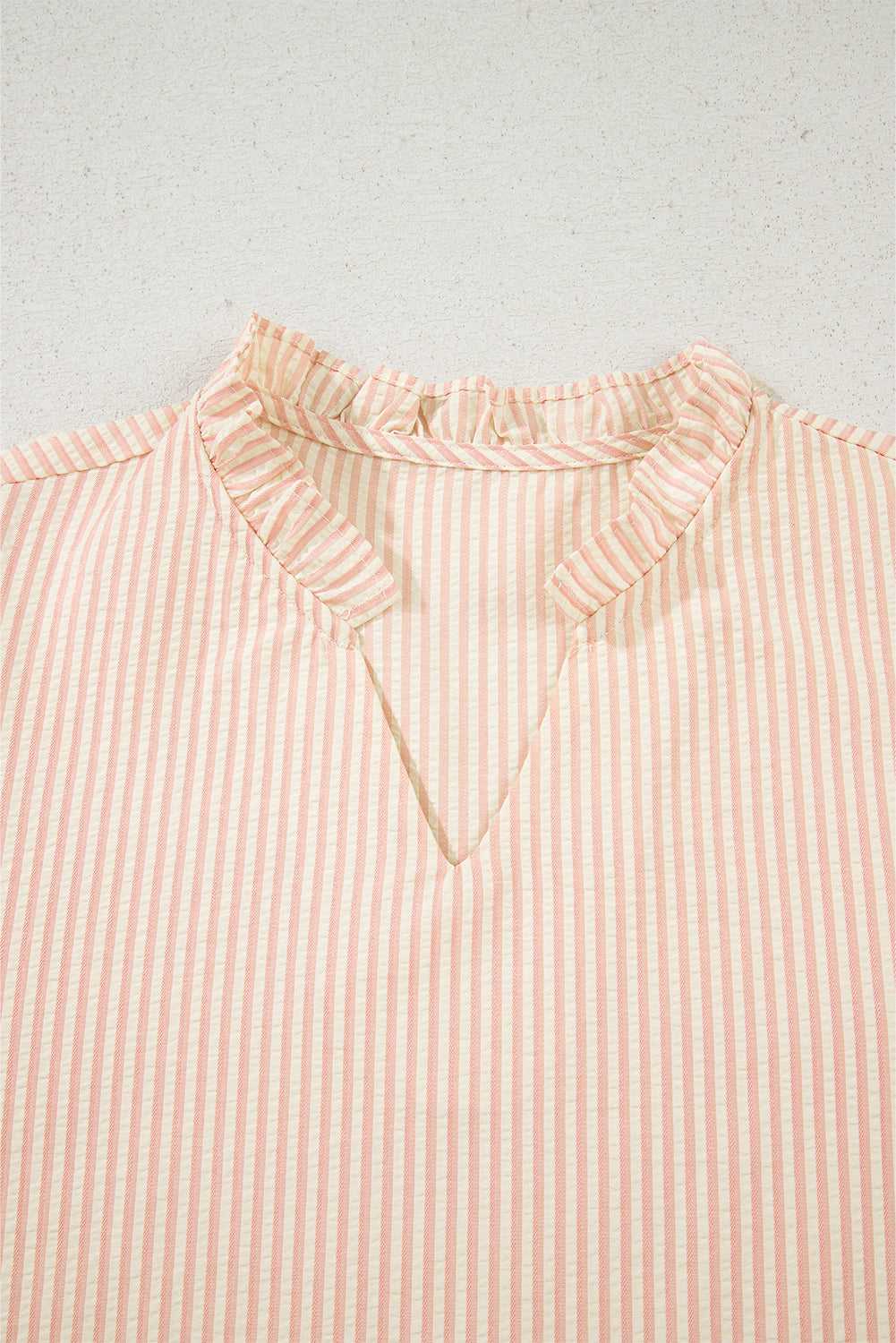 Close-up of the ruffled V-neckline on the Bow Cuff Pearl Embellished Blouse, showcasing elegant striped fabric detail.