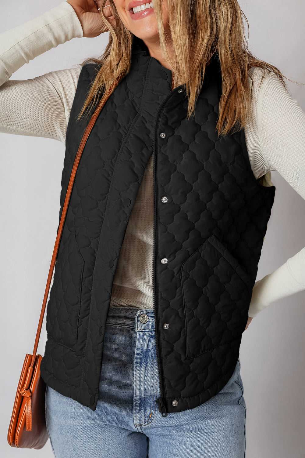Black Flower‑Quilted Winter Gilet styled with jeans and long-sleeve top, featuring zip and snap-button closure for versatile winter layering.