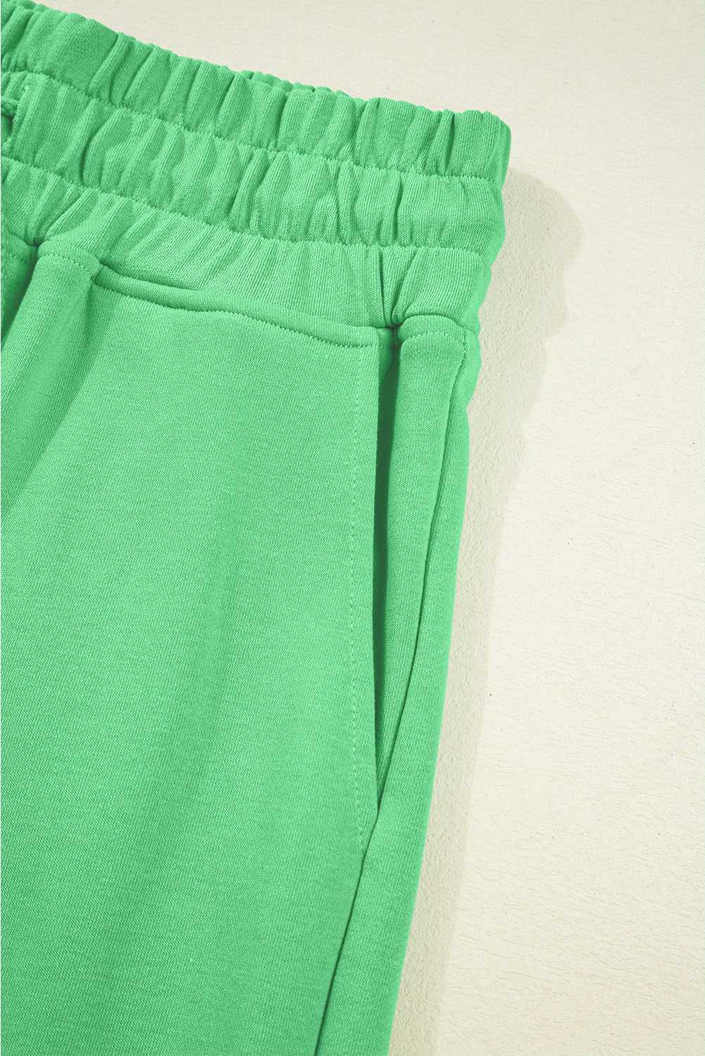 Side pocket and waistband detail of green Drop Crop Pants, perfect for casual wear with practical storage.