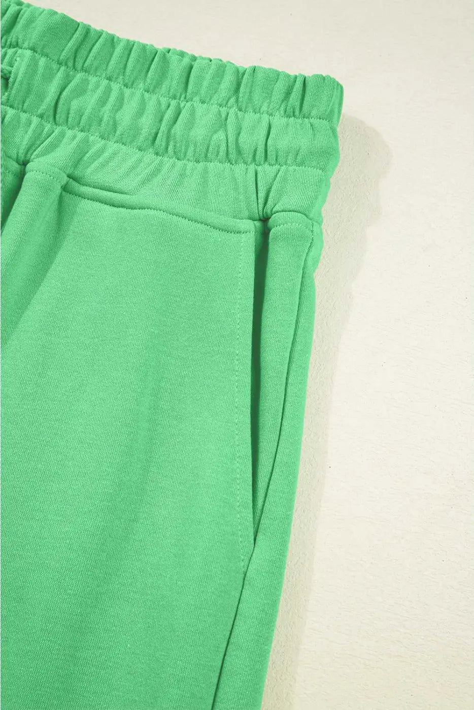 Side pocket and waistband detail of green Drop Crop Pants, perfect for casual wear with practical storage.