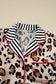 Leopard print long‑sleeve relaxed top with black and white striped collar on a beige background