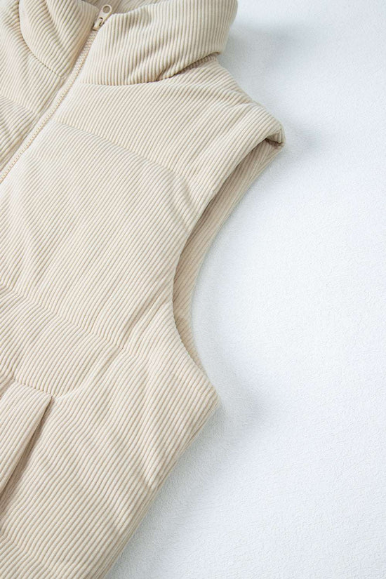 Armhole and upper section of beige corduroy puffer gilet, highlighting sleeveless cut and textured corduroy fabric.