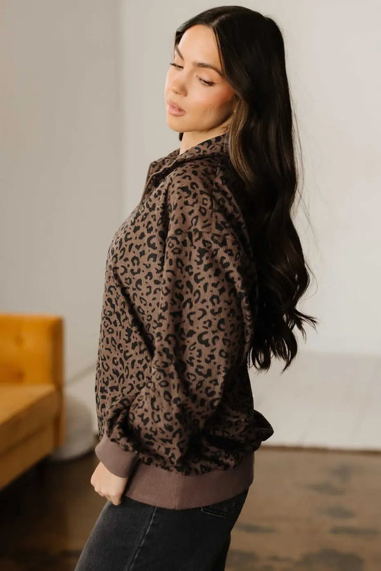 Side profile of model wearing Women's Brown Leopard Print Corduroy Half-Zip Jumper, highlighting loose sleeves and soft texture.