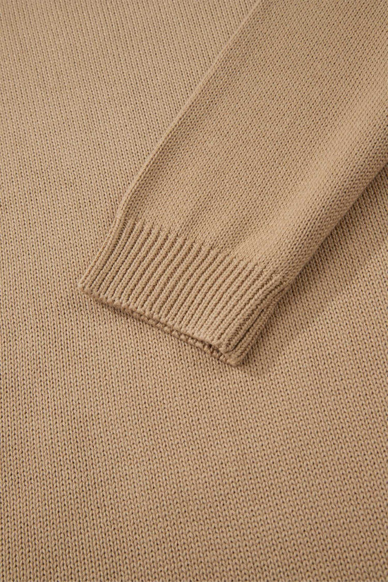 Close-up of a beige sweater with ribbed trim