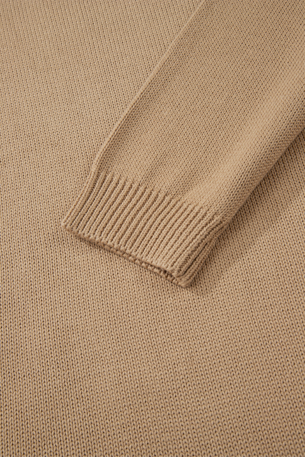 Close-up of a beige sweater with ribbed trim