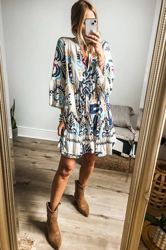 Model wearing the Tribal Mini Dress with bracelet sleeves and cowboy boots, styled for a casual bohemian spring look.