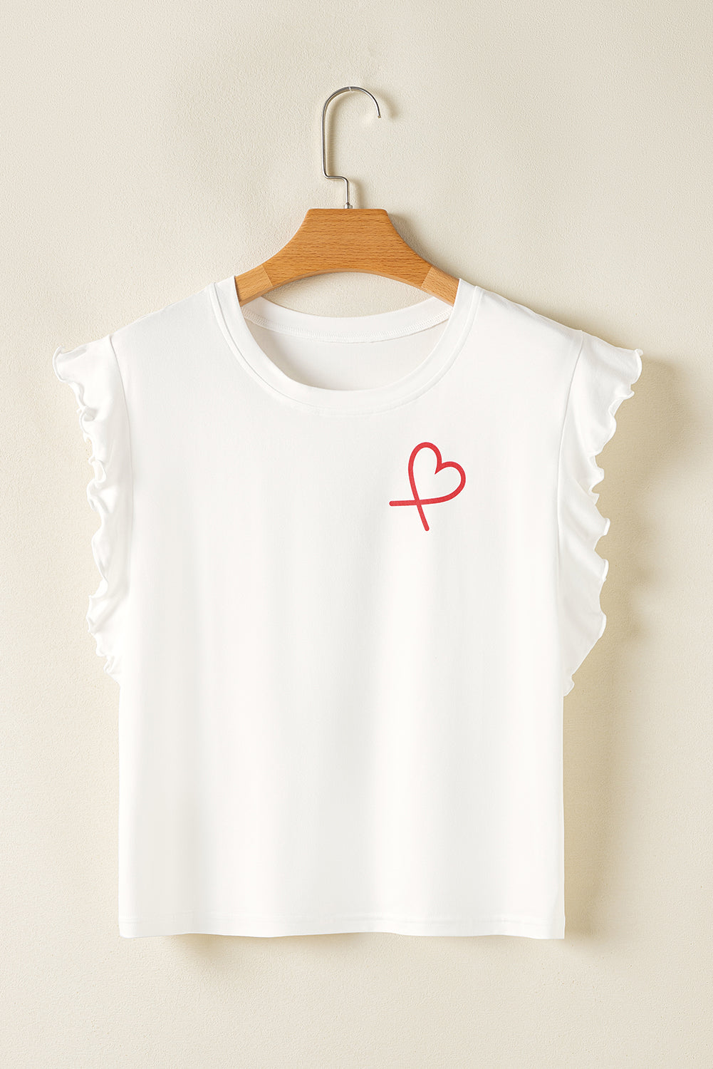 White sleeveless top with a red heart design on a beige background