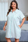 Woman wearing a light blue and white striped dress standing in a living room.