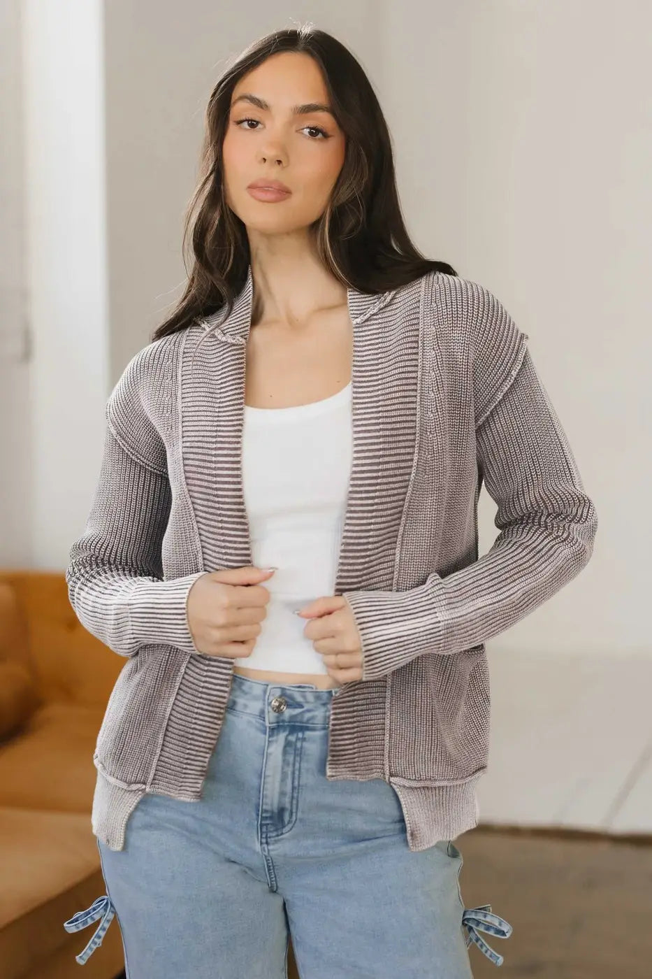 Model wearing brown Women's Stonewash Patchwork Knit Open Cardigan over white tank top and jeans, styled for casual wear.