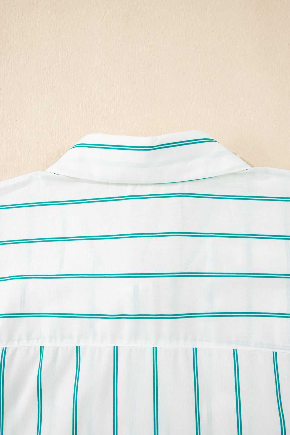 Close-up of a white shirt with green stripes on a beige background