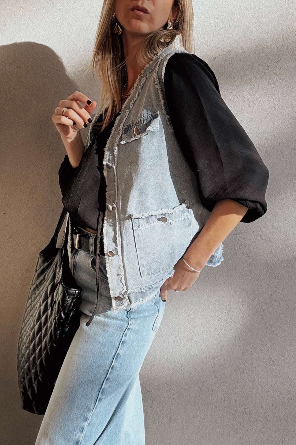 Beau Blue Denim Waistcoat with Frayed Edges paired with a black blouse and light wash jeans, styled with a black quilted tote bag for contrast.