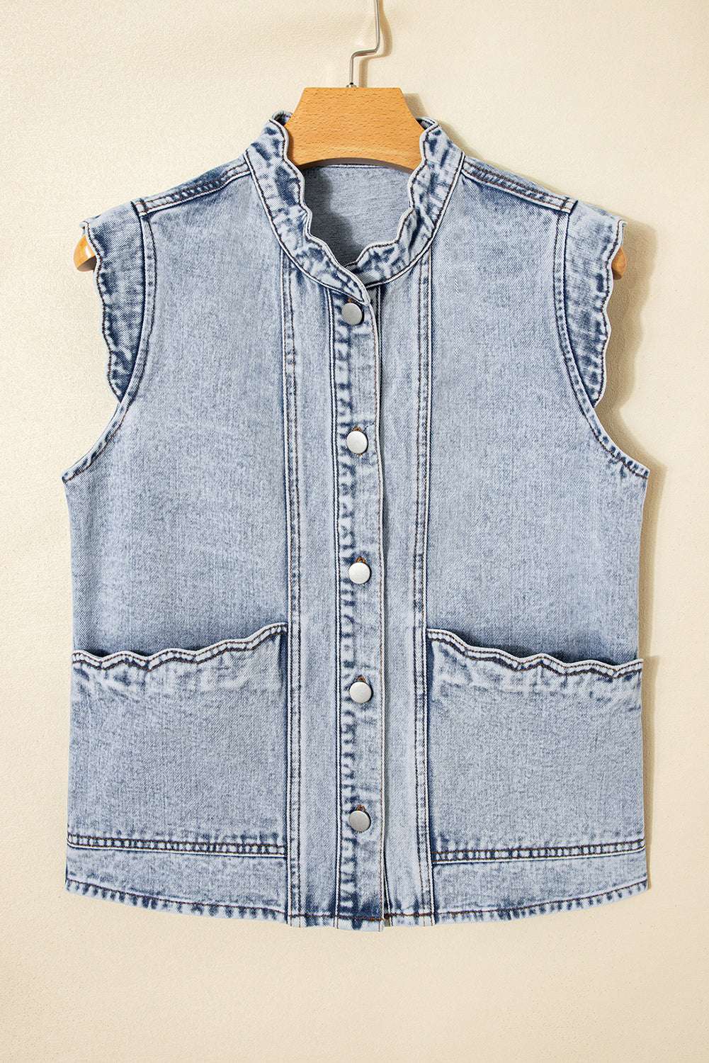 Flat lay of Beau Blue Scallop‑Trim Denim Waistcoat on hanger, featuring scallop trim collar and front flap pockets in soft denim.