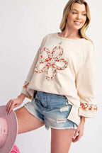 Model wearing Beige Flower Patch Graphic Top with colorful flower applique and relaxed fit, perfect for daily spring fashion.