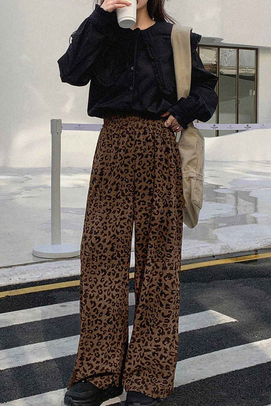 Street-style leopard corduroy trousers women in brown, styled with a black blouse and casual accessories for a modern fall look.