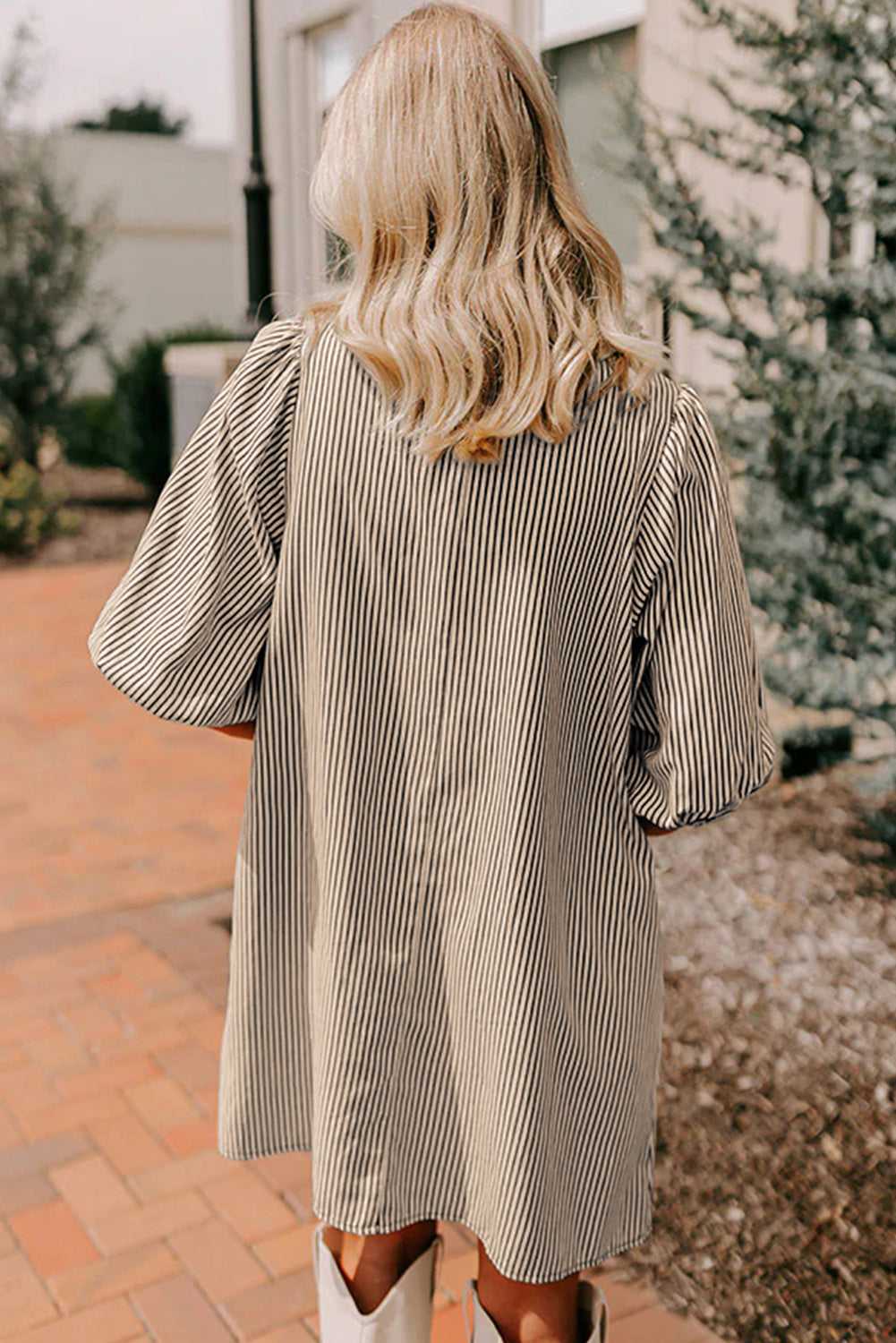 Back view of monochrome striped puff sleeve mini dress showing relaxed fit and lightweight fabric, perfect for casual summer styling.