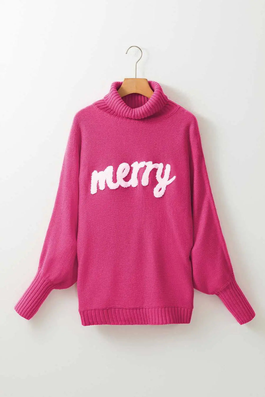 Pink high neck sweater with white 'merry' embroidery, ideal for festive Christmas looks and cozy winter fashion.